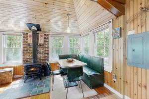 a dining room with a table and a stove at Sebago Shores Cottage in North Sebago