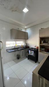 a kitchen with a white tiled floor and a stove at Casa do Mascarenhas in Picos