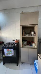 a kitchen with a stove and an open cabinet at Casa do Mascarenhas in Picos