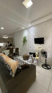a living room with a couch and a tv on a wall at Casa do Mascarenhas in Picos