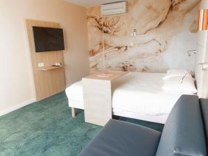 a hotel room with a bed and a painting on the wall at ibis Styles Chinon in Chinon