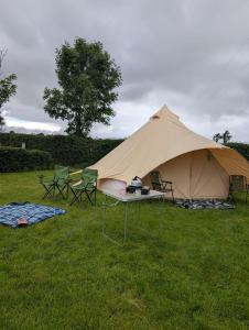 a tent with two chairs and a table in a field at Hal`s at Killynick in Killyhevlin