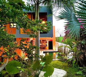 a house with a palm tree in a garden at Beautiful private villa with an ecological pool in Santa Maria Huatulco