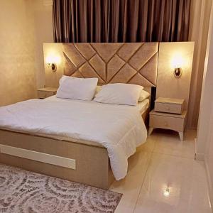 a bedroom with a large bed with a large headboard at السعودي للشقق الفندقيه in Az Zarqa
