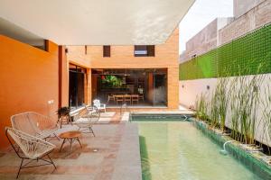 a house with a pool and chairs and a table at Beautiful private villa with an ecological pool in Santa Maria Huatulco