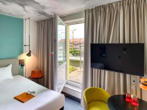 a hotel room with a bed and a balcony at ibis Berlin Kurfuerstendamm in Berlin
