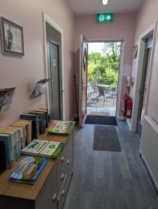 a room with a desk with books and a door to a patio at Hal`s at Killynick in Killyhevlin
