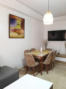 a living room with a dining room table and chairs at L'hivernage andalouse 4 in Marrakesh