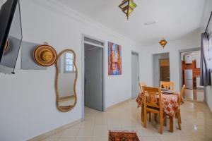 a dining room with a table and chairs and a mirror at Dar Tilila in Essaouira