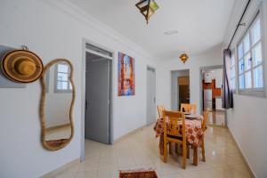 a dining room with a table and a mirror at Dar Tilila in Essaouira