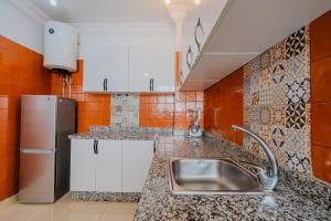 a kitchen with a sink and a refrigerator at Dar Tilila in Essaouira
