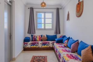 a living room with a couch and a window at Dar Tilila in Essaouira