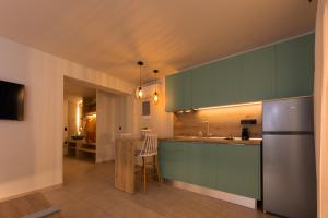a kitchen with green cabinets and a stainless steel refrigerator at Thrive in Sarti