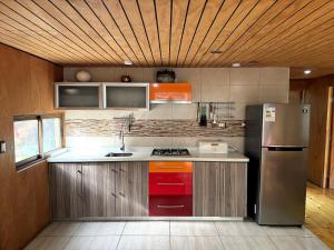 a kitchen with a stainless steel refrigerator and cabinets at Santuario Lodge Arrayan in Lo Barnechea