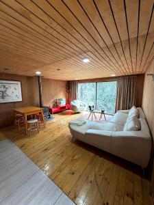 a large bed in a room with a wooden ceiling at Santuario Lodge Arrayan in Lo Barnechea