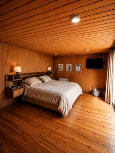 a bedroom with a bed and a wooden ceiling at Santuario Lodge Arrayan in Lo Barnechea
