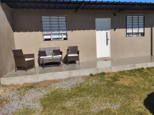 a patio with chairs and a table in front of a house at Casa bella in Durazno