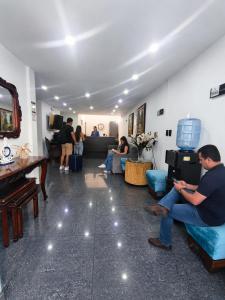 a man sitting on a couch in a living room at Hotel Siglo 21 in Cali