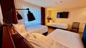 a hotel room with two beds and a tv at Hotel Oliver in Bogotá