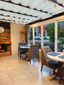 a living room with a table and chairs and a fireplace at Pousada Quinta do Vale in Gramado