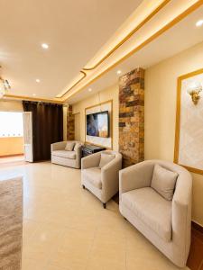 a living room with two chairs and a couch at Hadayek Al-Ahram Guest House - حدائق الاهرام جيست هاوس in Giza