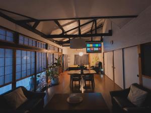 a living room with a couch and a table at 愛犬と泊まれる宿 ほこほこsaza 一棟貸し 海も川も徒歩圏内 dog run付き 釣りの穴場 サーフィン 自然 満点星空 蛍鑑賞 最大7名 in Miyazaki