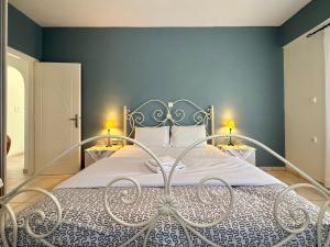 a bedroom with a white bed with blue walls at Villa Fenia in Aegiali