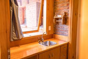 eine Küche mit Spüle und Fenster in der Unterkunft Casa 45 in San Martín de los Andes