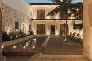 a house with a swimming pool and a palm tree at Villa Mineli in Campeche