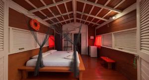 a bedroom with a bed in a room with windows at Pousada Vettore in Atins