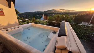 a hot tub on the balcony of a house at Hillside Cottage in Pécs