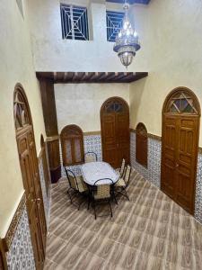 a dining room with a table and a chandelier at Riad Al Anwar in Rabat