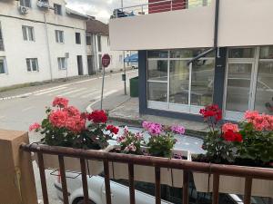 a balcony with flowers on a building with a stop sign at Sladjana apartman in Prijepolje