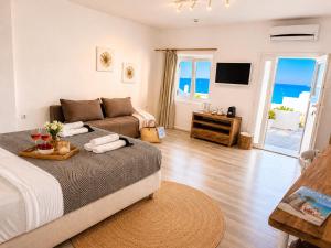 a living room with a bed and a couch at With-inn Mykonos Suites in Tourlos +181 photos