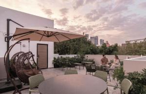 two people sitting on a rooftop patio with an umbrella at Casa Grijalva by Kukun Apartments in Mexico City