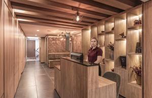 a woman standing at a counter in a lobby at Casa Grijalva by Kukun Apartments in Mexico City