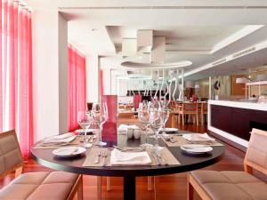 a dining room with a table with wine glasses at Hotel Mercure Braga Centro in Braga