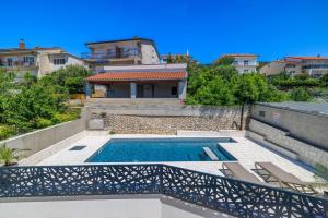 a villa with a swimming pool and a house at Apartments Maja in Selce