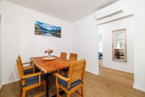 a dining room with a wooden table and chairs at Apartments Maja in Selce