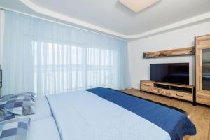 a bedroom with a bed and a flat screen tv at Apartments Maja in Selce
