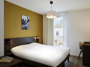 a bedroom with a white bed and a window at Aparthotel Adagio Access Poitiers in Poitiers