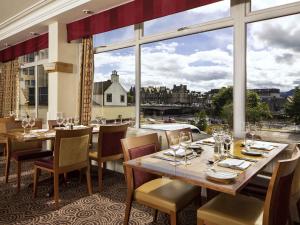 a restaurant with tables and chairs and a large window at Mercure Inverness Hotel in Inverness