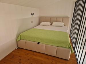 a bedroom with a bed with a green blanket on it at Blue Horizon Rezevici in Katun