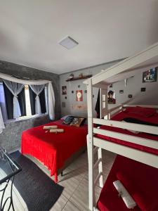 a bedroom with two bunk beds and a red blanket at Suíte Harry Potter - Pousada Castelo do Luar in Penha