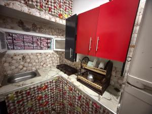 a kitchen with red cabinets and a stove at Katalan in Martil