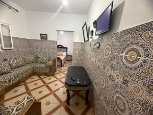 a living room with a couch and a tv on a wall at Katalan in Martil