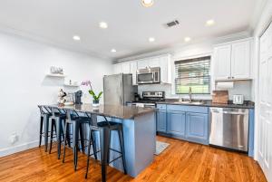 a kitchen with blue cabinets and counter stools at Saturdays In The South in Auburn