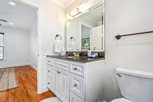 a white bathroom with a sink and a mirror at Saturdays In The South in Auburn +6 photos