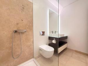 a bathroom with a toilet and a glass shower at T2 Dunas Esposende in Esposende