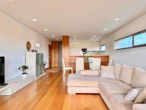 a living room with a couch and a kitchen at T2 Dunas Esposende in Esposende